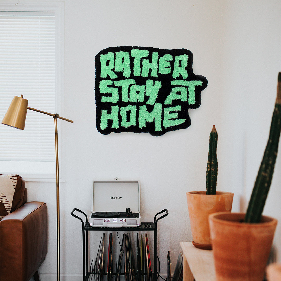 studio yarnatak rather stay at home medium wall rug green and black on white wall in cool living room with plants